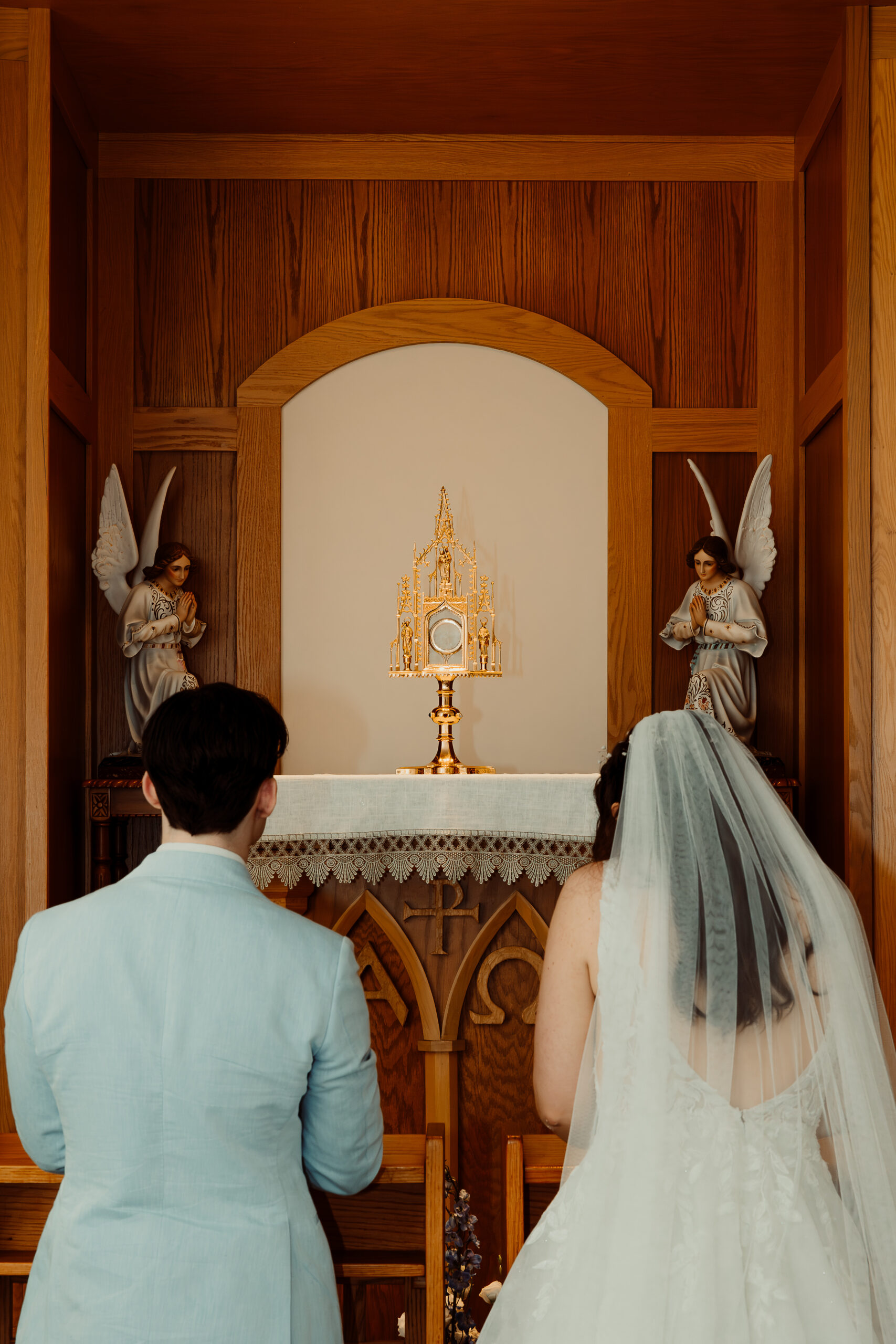 New husband and wife kneel before the Lord